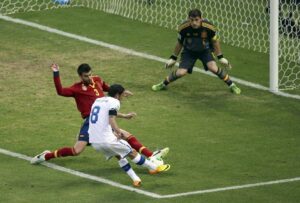 Spain's Gerard Pique blocks a shot by Italy's Claudio Marchisio in front of goalkeeper Iker Casillas during their Confederations Cup semi-final soccer match at the Estadio Castelao in Fortaleza