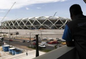 A worker observes the Arena Amazonia soccer stadium after a worker fell to his death in Manaus