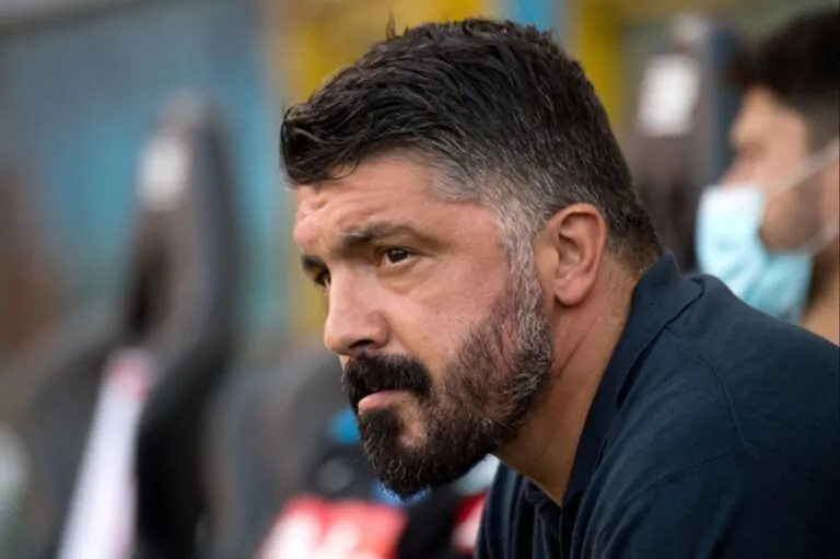 alt="Gennaro Gattuso pensieroso a bordo campo con sfondo azzurro e bandiera italiana stilizzata"